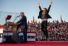 Tesla CEO Elon Musk jumps on stage as he joins Donald Trump during a campaign rally. Photo by Jim WATSON / AFP 