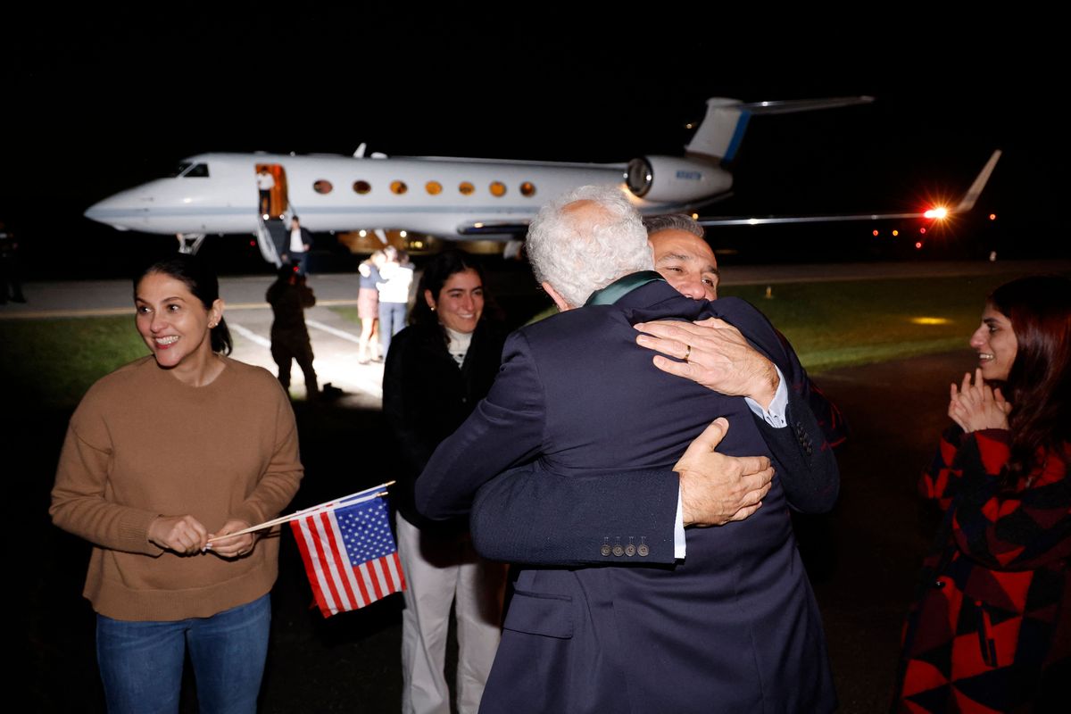 Freed US national Emad Shargi (C R) greets a family member. (Photo by JONATHAN ERNST/POOL/AFP via Getty Images)