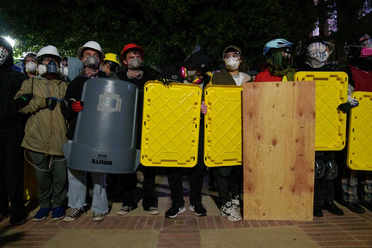 Pro-Palestine Protestors stand with shields at an encampment at UCLA. (Photo by Eric Thayer/Getty Images)