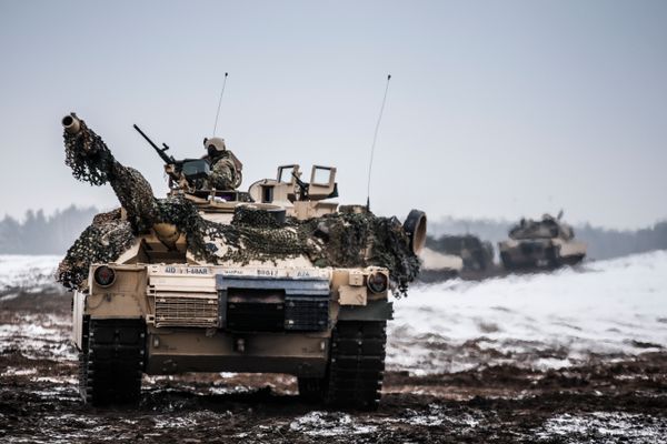 A convoy of M1 Abrams main battle tanks move through open ground. Image: NATO / Flickr